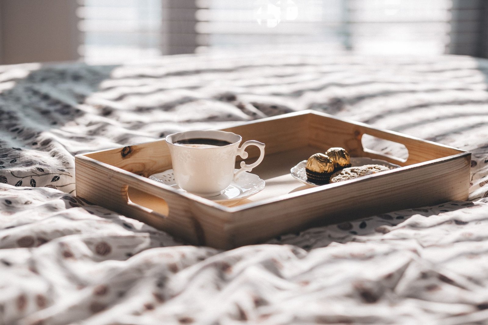 Vassoio per la colazione con tazza e dolci su un letto accogliente